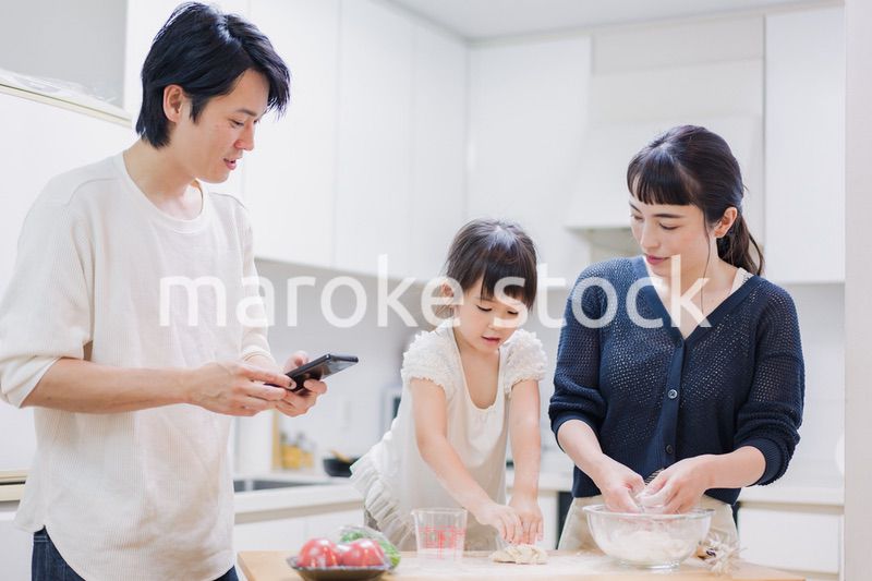 レシピを調べながら料理をするファミリー