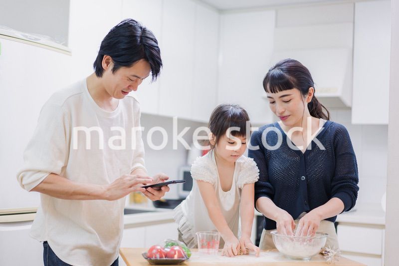 レシピを調べながら料理をするファミリー