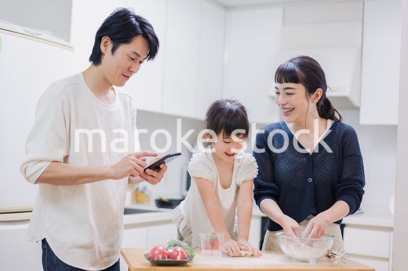 レシピを調べながら料理をするファミリー