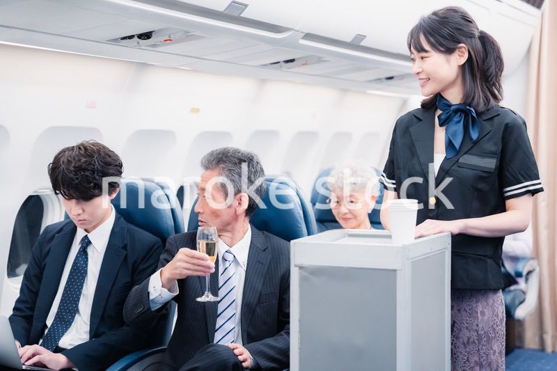 機内で飲み物を提供するキャビンクルー