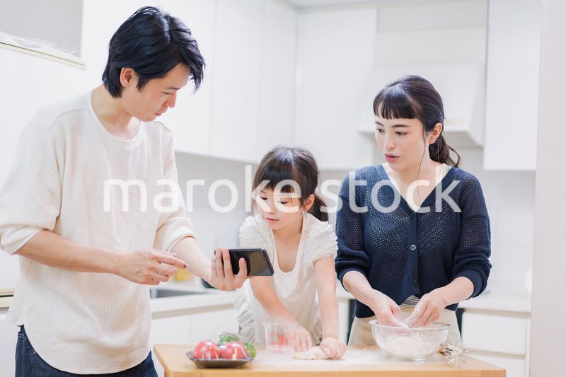 レシピを調べながら料理をするファミリー