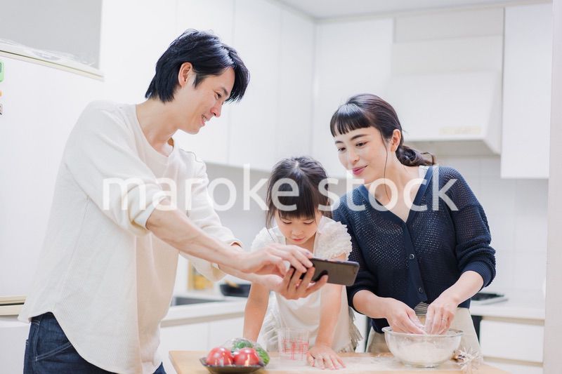 レシピを調べながら料理をするファミリー