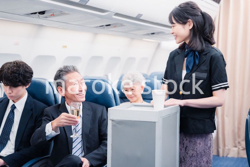 機内で飲み物を提供するキャビンクルー
