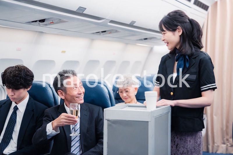 機内で飲み物を提供するキャビンクルー