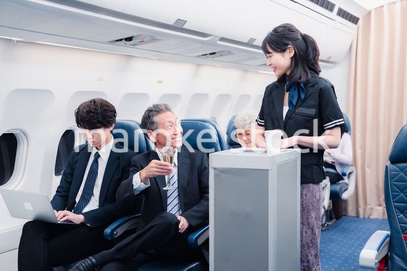 機内で飲み物を提供するキャビンクルー