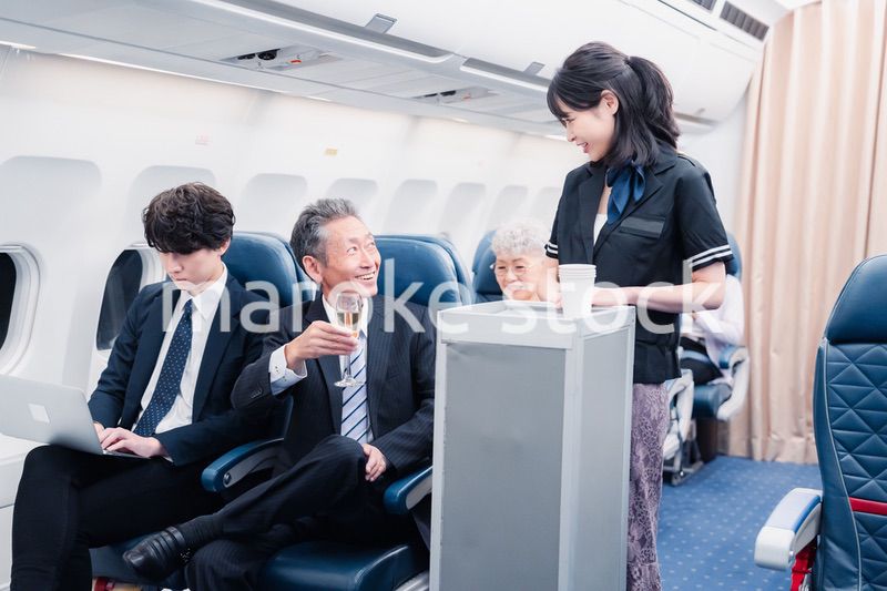 機内で飲み物を提供するキャビンクルー