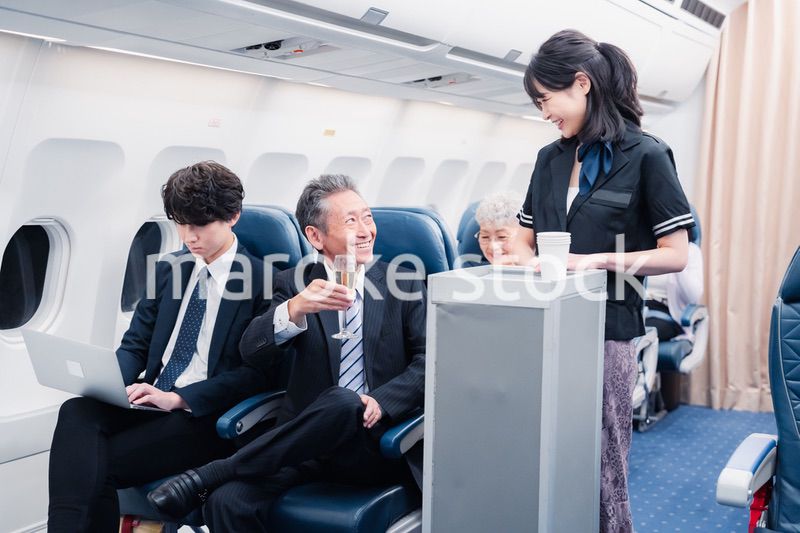 機内で飲み物を提供するキャビンクルー