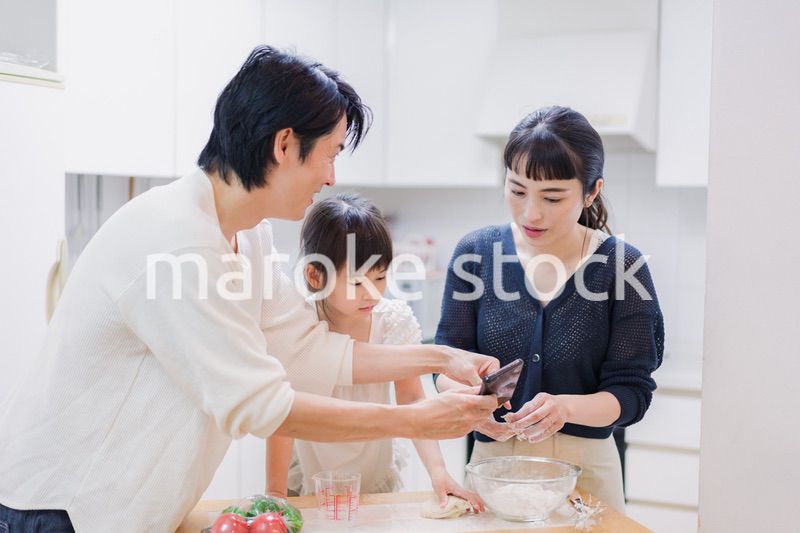レシピを調べながら料理をするファミリー