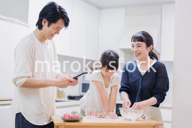 レシピを調べながら料理をするファミリー