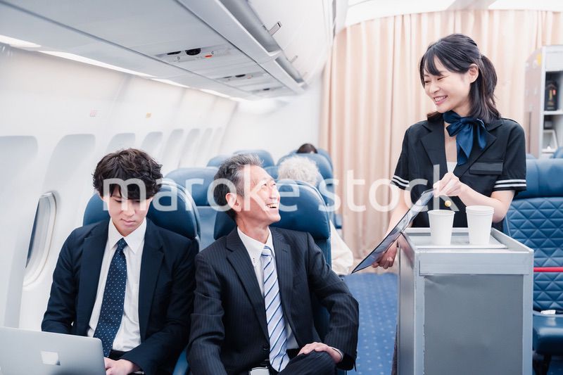 機内で飲み物を提供するキャビンクルー