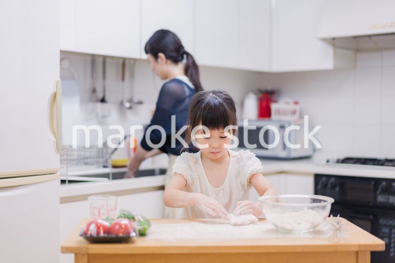 料理を手伝う女の子とお母さん