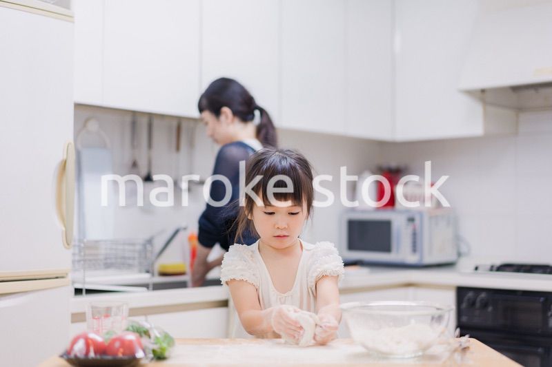 料理を手伝う女の子とお母さん