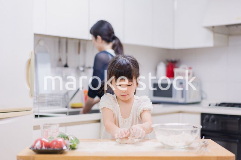 料理を手伝う女の子とお母さん
