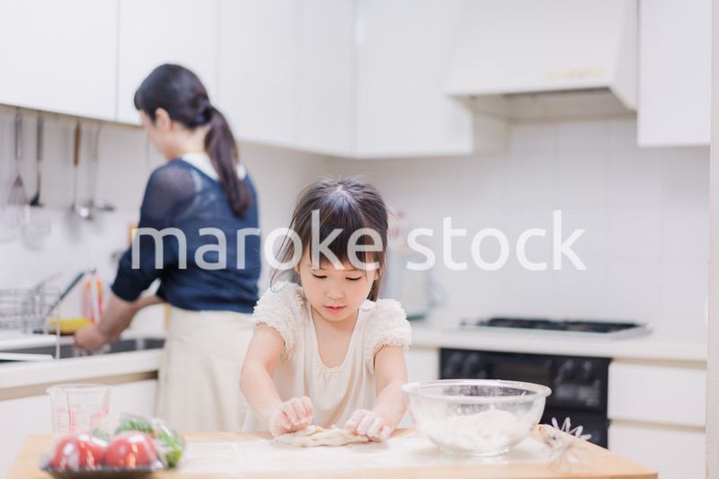 料理を手伝う女の子とお母さん