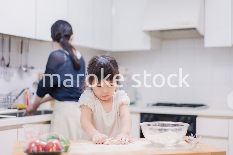 料理を手伝う女の子とお母さん