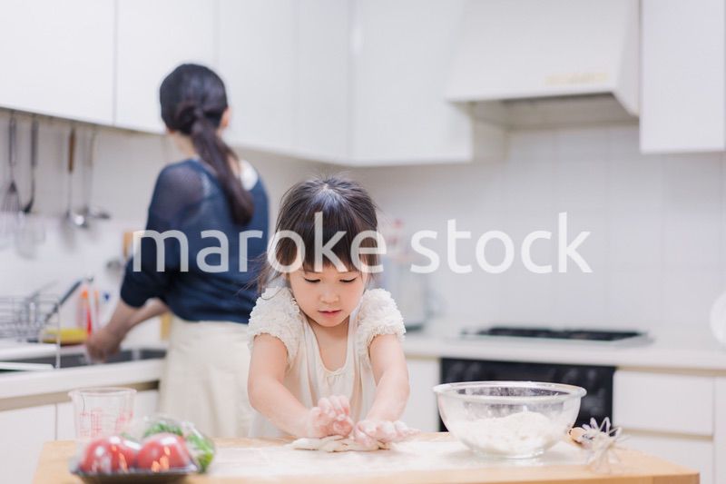 料理を手伝う女の子とお母さん