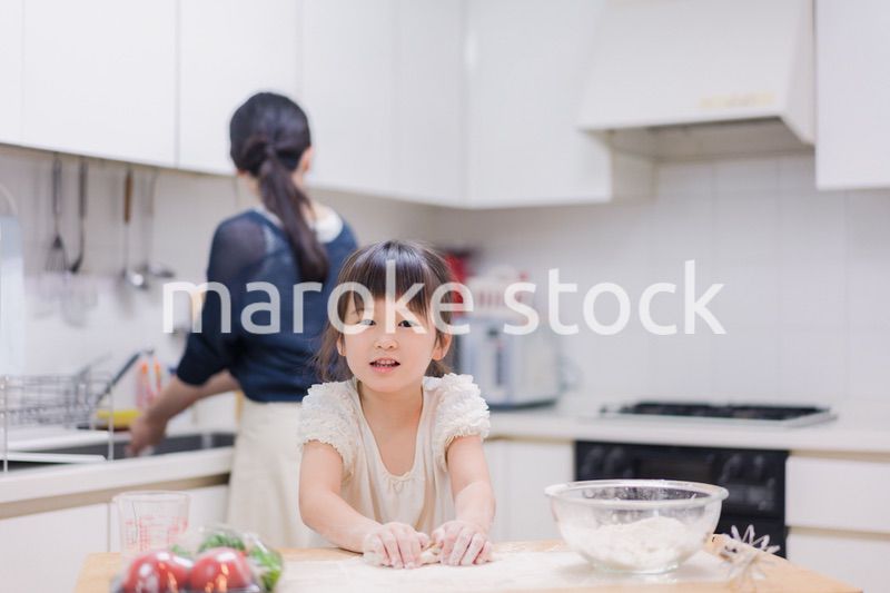 料理を手伝う女の子とお母さん
