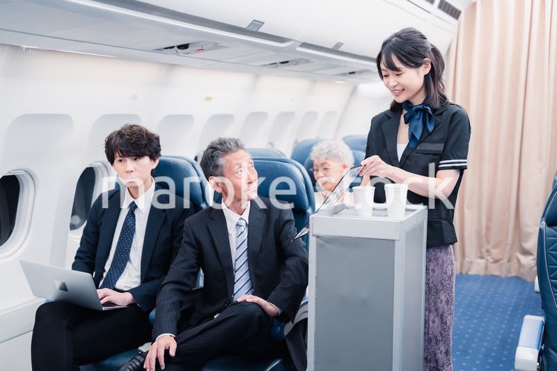 機内で飲み物を提供するキャビンクルー
