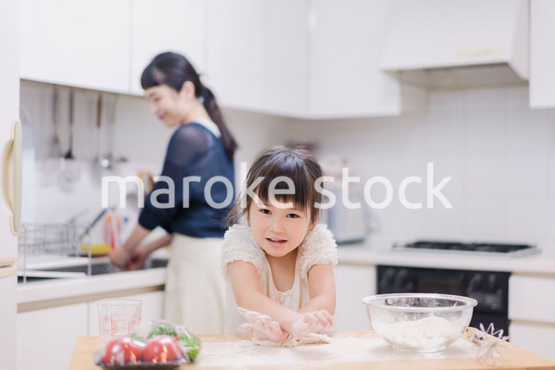 料理を手伝う女の子とお母さん