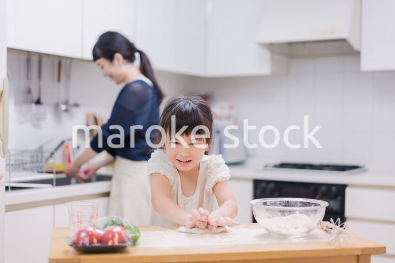 料理を手伝う女の子とお母さん