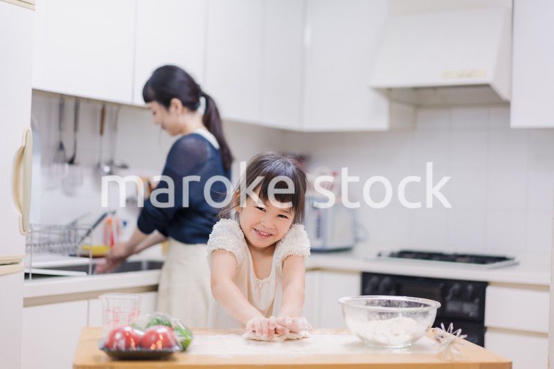 料理を手伝う女の子とお母さん