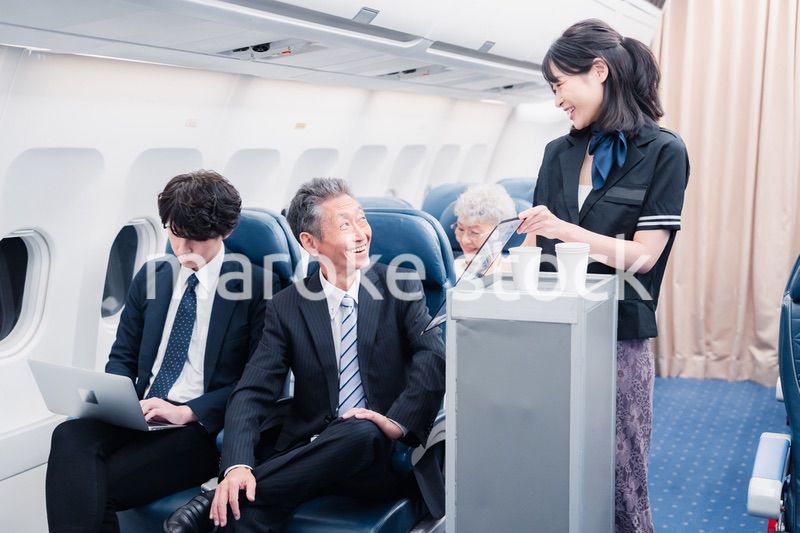 機内で飲み物を提供するキャビンクルー