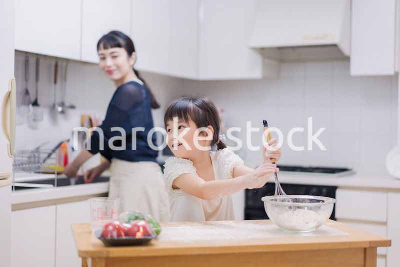 料理を手伝う女の子とお母さん