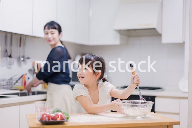 料理を手伝う女の子とお母さん