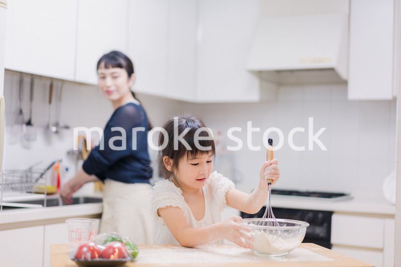 料理を手伝う女の子とお母さん