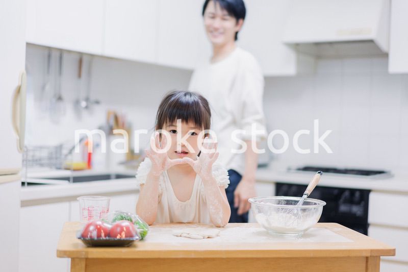 パパと一緒にクッキングをする小さな女の子