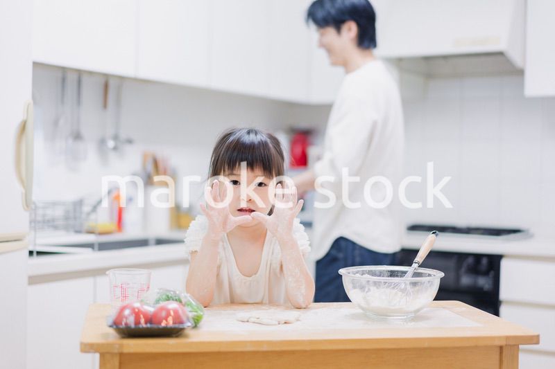 パパと一緒にクッキングをする小さな女の子