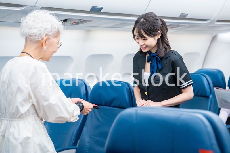 高齢の乗客を案内するキャビンアテンダント