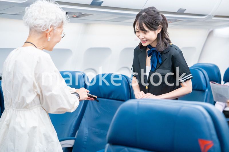高齢の乗客を案内するキャビンアテンダント