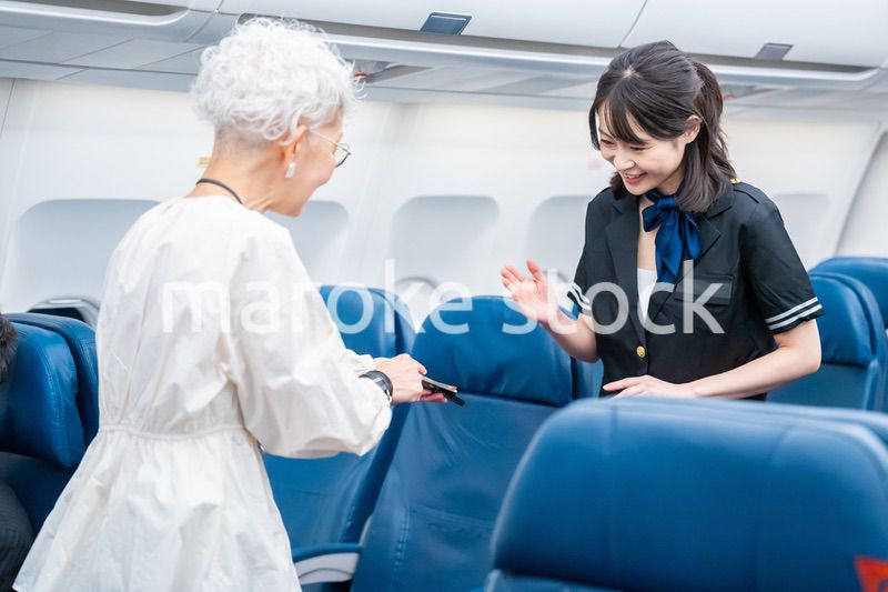 高齢の乗客を案内するキャビンアテンダント