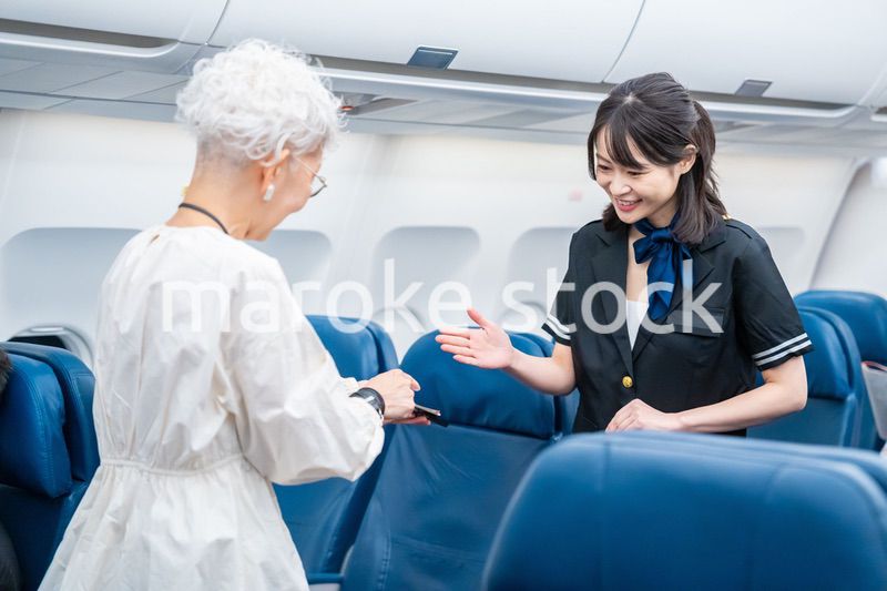 高齢の乗客を案内するキャビンアテンダント