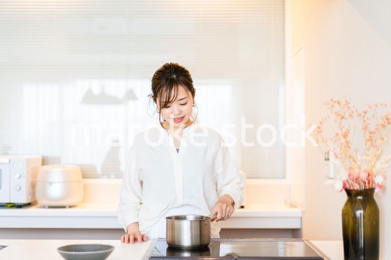おうちのキッチンで料理をする主婦