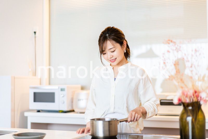 おうちのキッチンで料理をする主婦