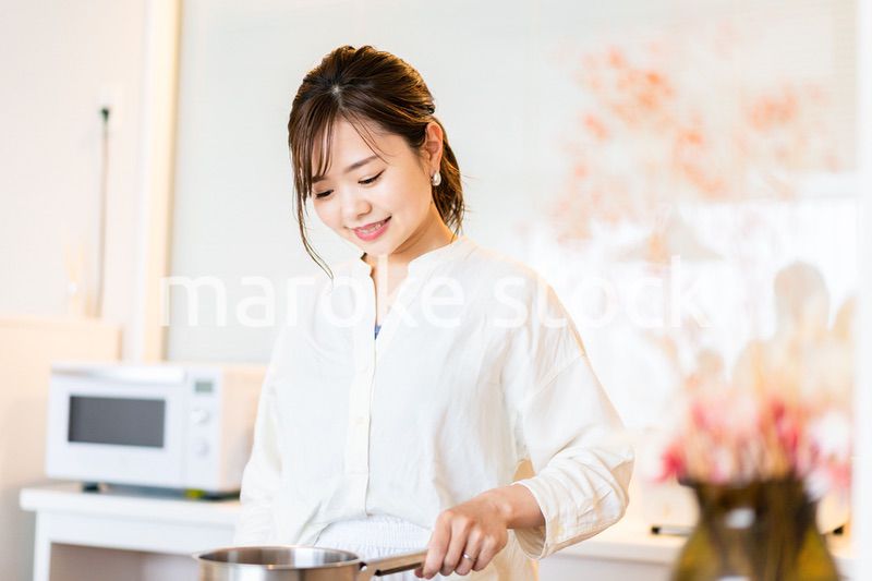 おうちのキッチンで料理をする主婦