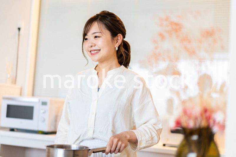 おうちのキッチンで料理をする主婦