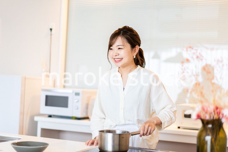 おうちのキッチンで料理をする主婦