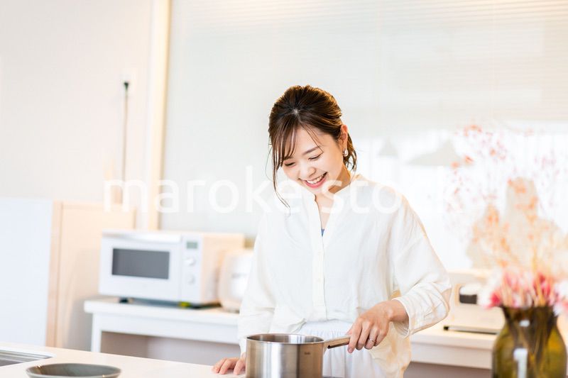 おうちのキッチンで料理をする主婦