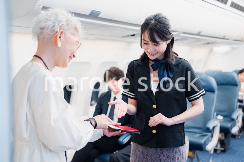 乗客に座席の案内をするキャビンアテンダント