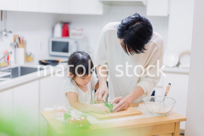 パパと一緒にクッキングをする小さな女の子
