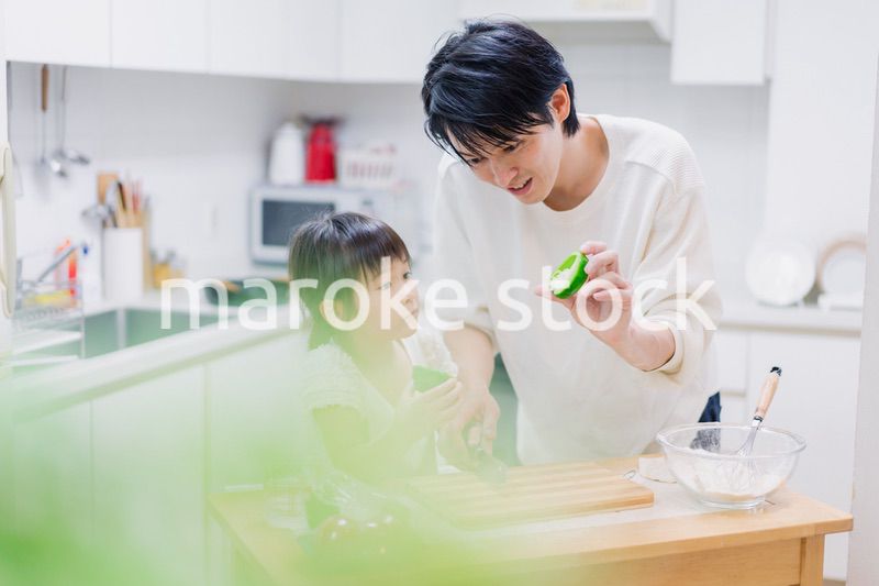 パパと一緒にクッキングをする小さな女の子