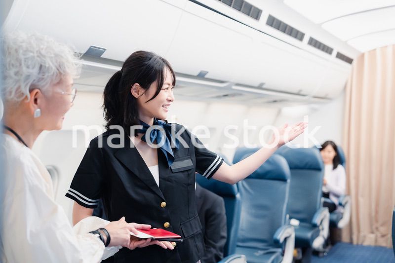乗客に座席の案内をするキャビンアテンダント