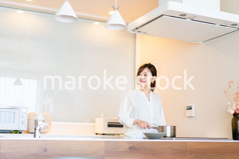 おうちのキッチンで料理をする主婦