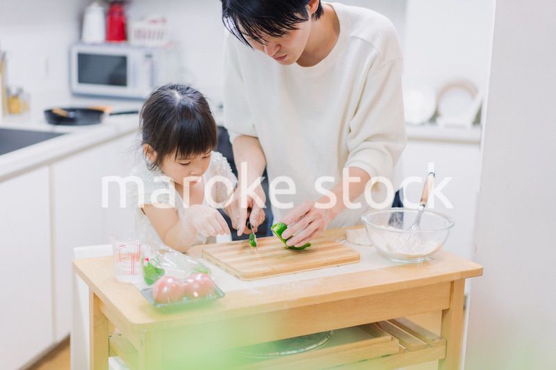 パパと一緒にクッキングをする小さな女の子