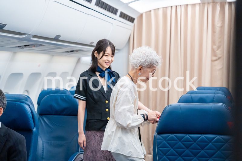 高齢の乗客を案内するキャビンアテンダント