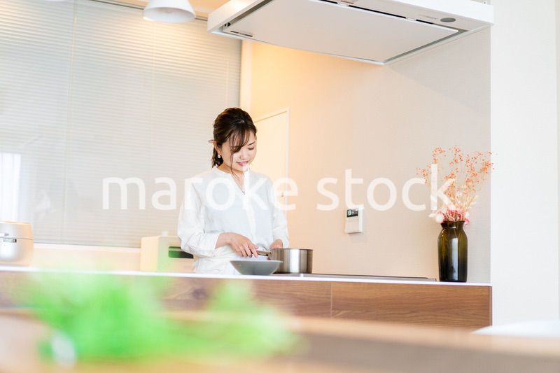 おうちのキッチンで料理をする主婦