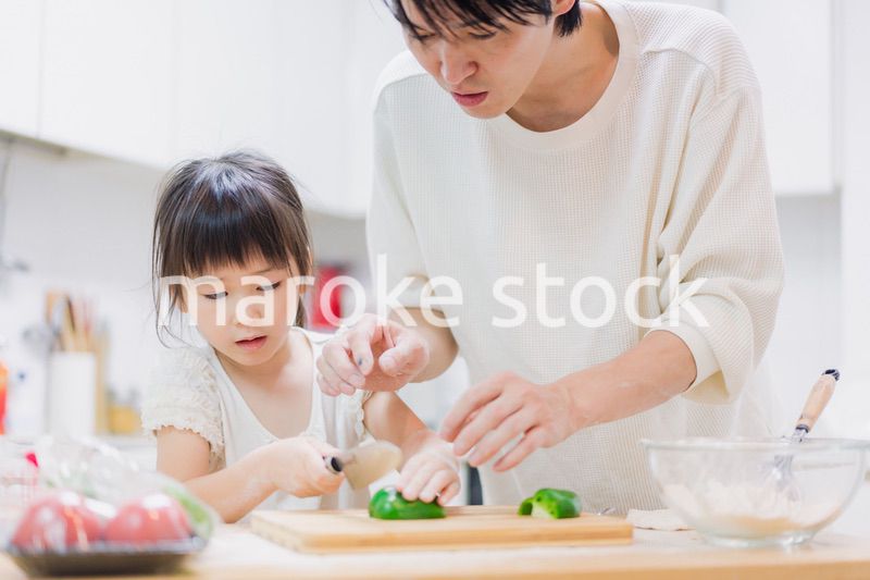 パパと一緒にクッキングをする小さな女の子